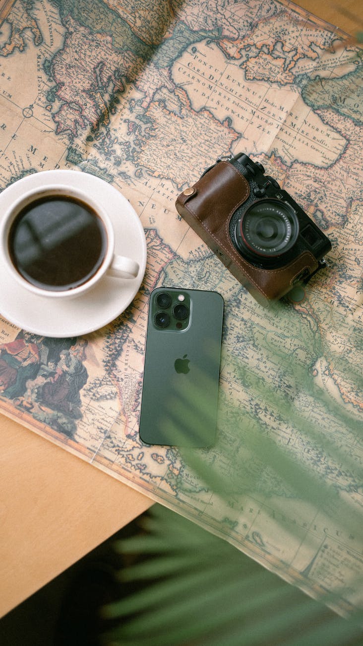 photo of coffee analog camera and smartphone spread out on a map